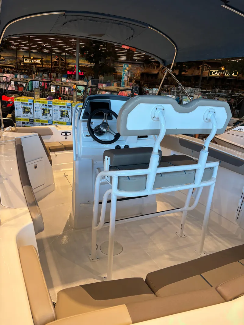 Slide: The Image of 2025 Tahoe 2150 CC boat interior with seating and steering console, displayed indoors. - 4