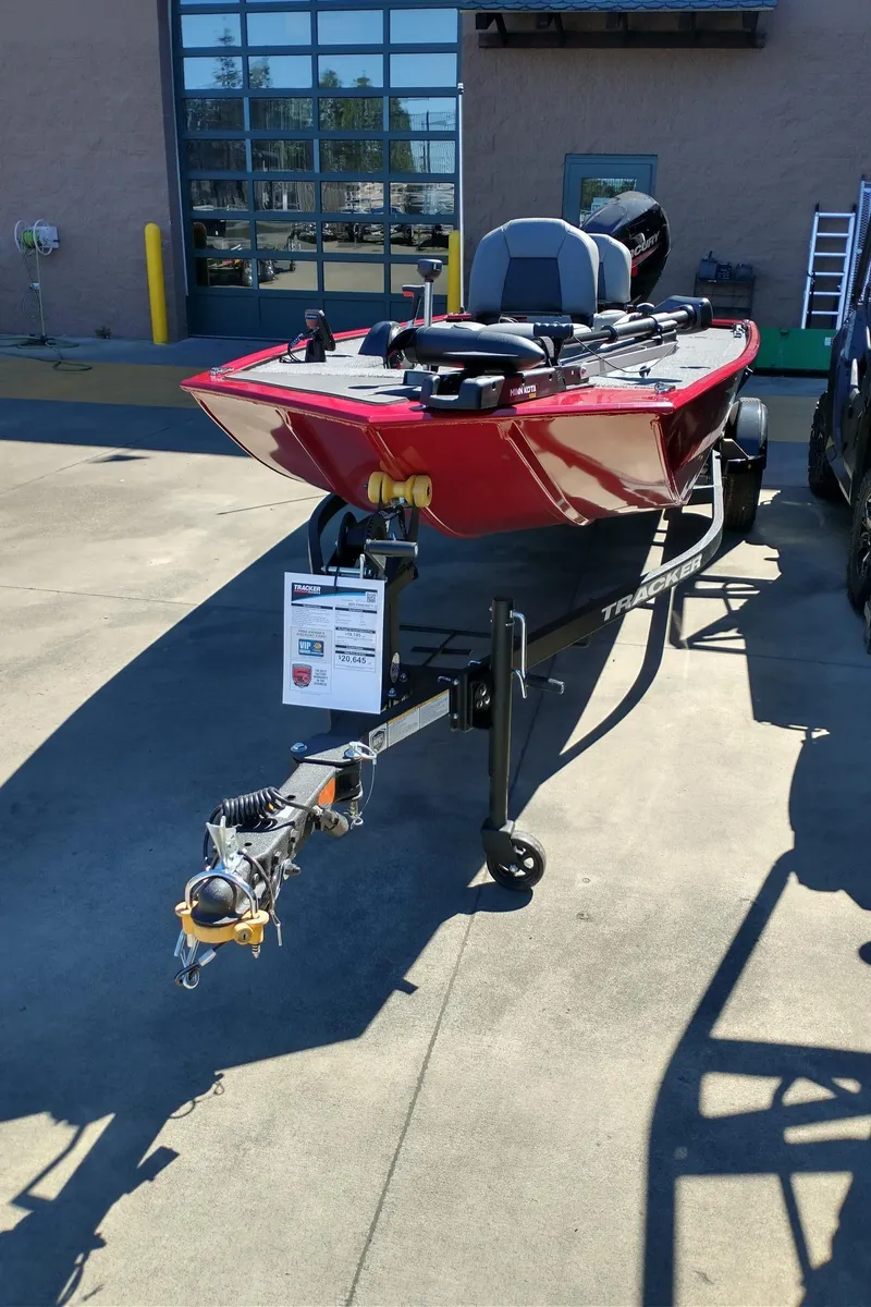 Slide: The Image of 2025 Tracker Panfish 17 boat with Mercury engine, red exterior, parked on trailer. - 3