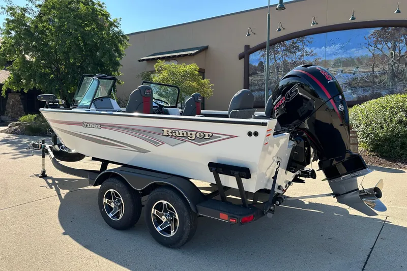 Slide: The Image of 2025 Ranger VS1882SC Angler boat on trailer, parked outdoors, featuring sleek design and powerful engine. - 2
