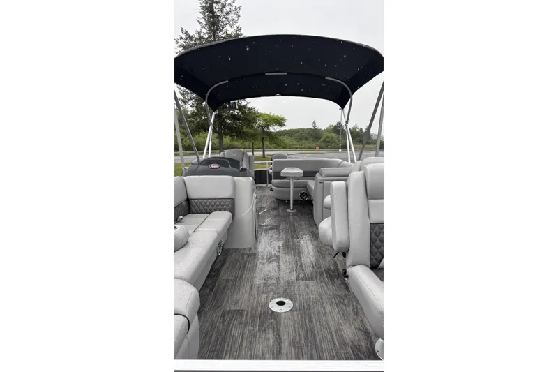 Slide: The Image of Interior of a 2025 Ranger Reata 220FC with gray seating and a black canopy. - 2