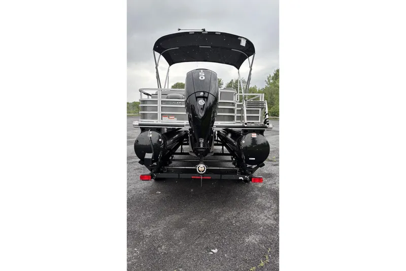 Slide: The Image of The image shows a Ranger Reata 220FC pontoon boat from the rear, featuring a large outboard motor and a black bimini top. - 4