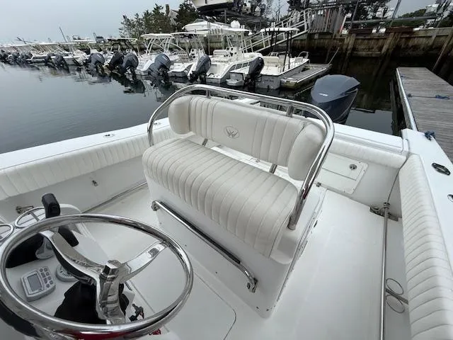 Slide: The Image of 2008 Southport 26 Center Console boat with white seating, docked in a marina. - 10
