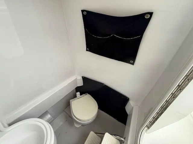 Slide: The Image of 2008 Southport 26 Center Console boat interior with compact marine toilet and storage. - 15