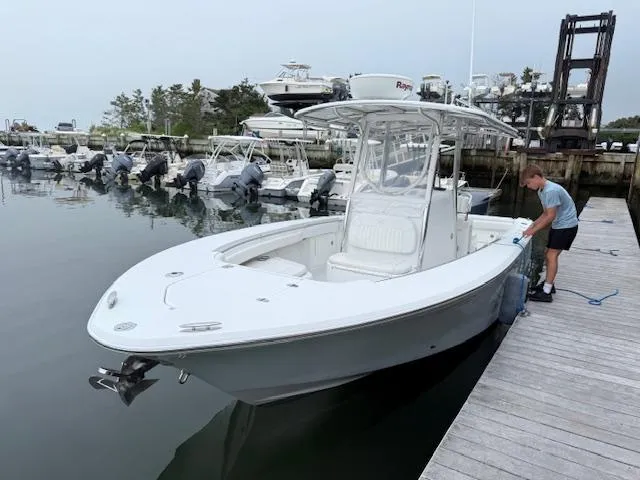 Slide: The Image of 2008 Southport 26 Center Console boat docked at marina with person securing it. - 2