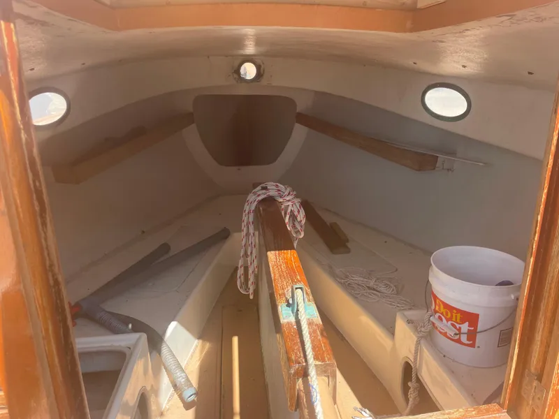 Slide: The Image of 1978 Marshall Sanderling sailboat interior with ropes and bucket, showcasing classic design. - 4