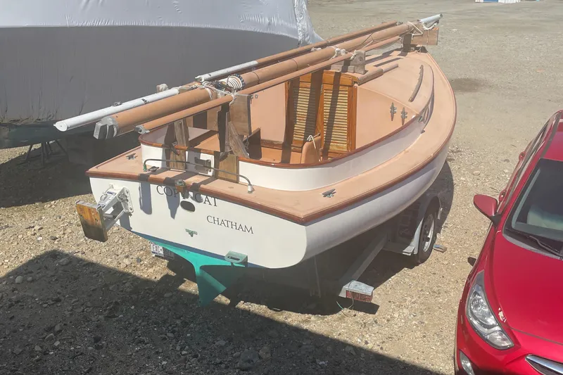 Slide: The Image of 1978 Marshall Sanderling sailboat on trailer, parked beside a red car. - 6