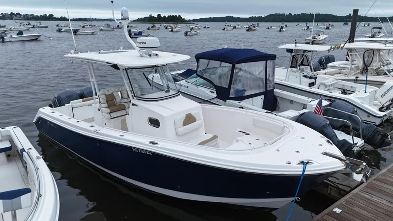 The Image of 2015 Edgewater 280CC boat docked among other vessels on a cloudy day. - 0