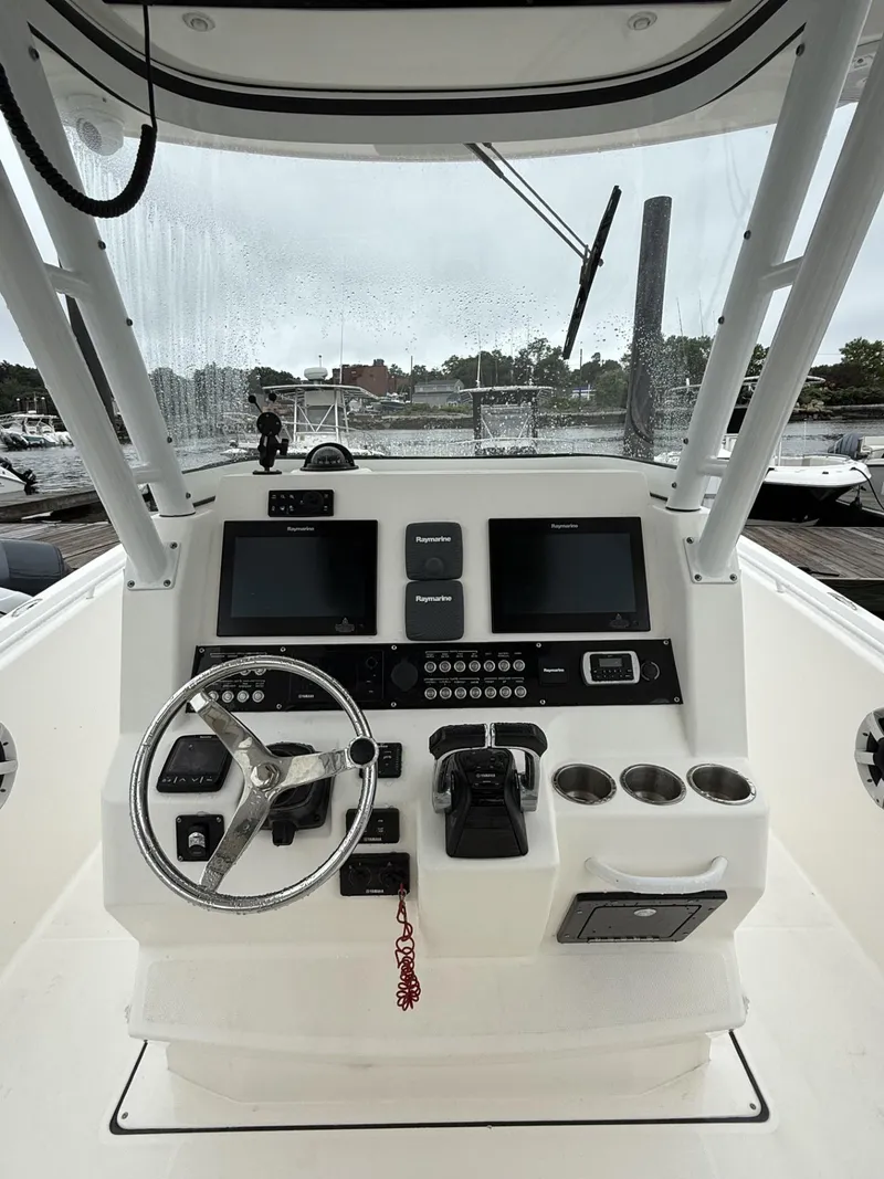 Slide: The Image of 2015 Edgewater 280CC boat dashboard with steering wheel and navigation screens. - 11