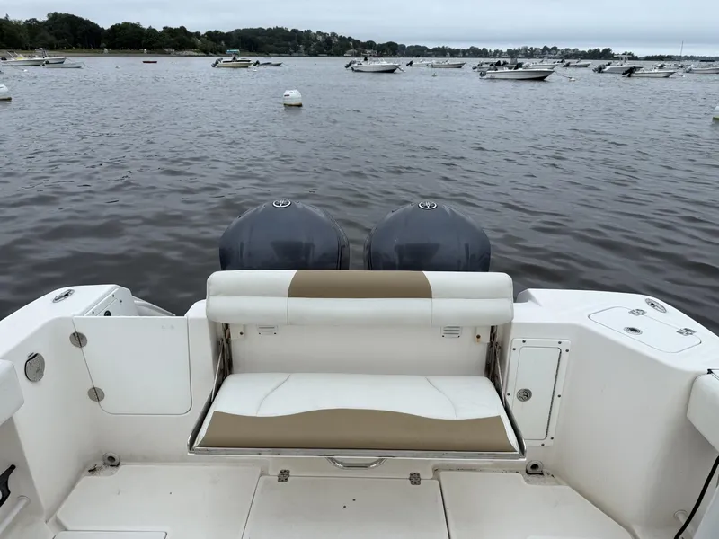 Slide: The Image of 2015 Edgewater 280CC boat with dual engines, docked in a calm marina. - 13