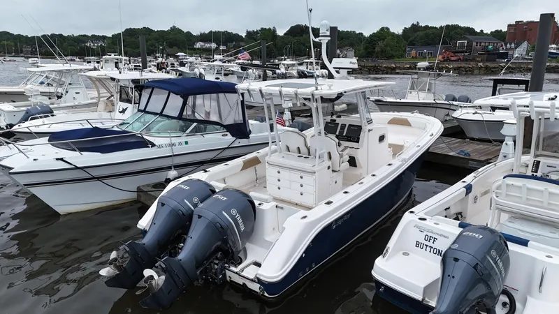 Slide: The Image of 2015 Edgewater 280CC boat docked with twin Yamaha engines, surrounded by other boats. - 3