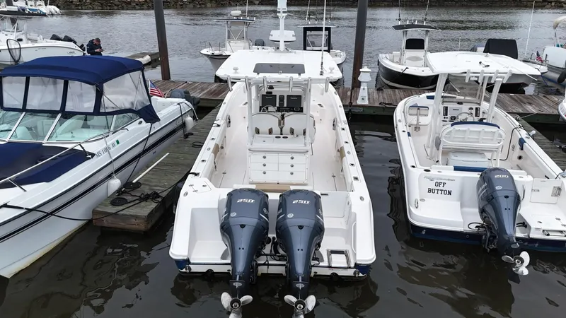 Slide: The Image of 2015 Edgewater 280CC boat docked with twin engines, surrounded by other boats. - 5