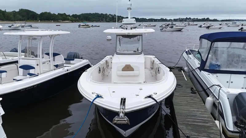 Slide: The Image of 2015 Edgewater 280CC boat docked among other vessels on a calm lake. - 6