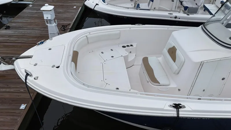 Slide: The Image of 2015 Edgewater 280CC boat docked, featuring spacious seating and sleek design. - 7