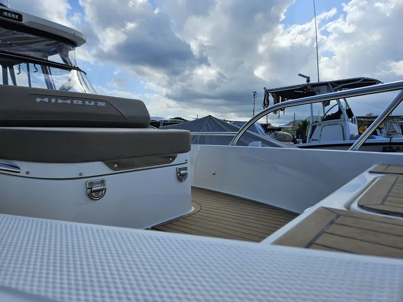 Slide: The Image of 2023 Nimbus Tender 8 boat deck with cushioned seating under cloudy sky. - 10