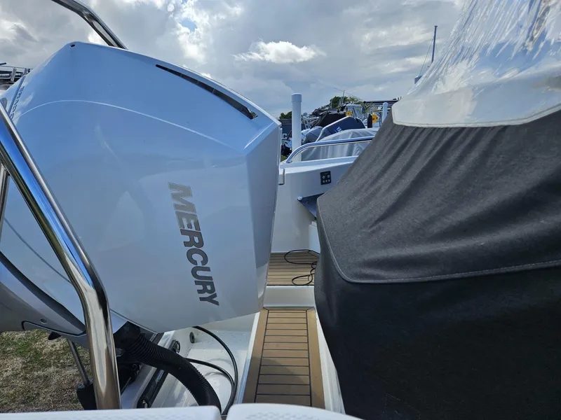 Slide: The Image of 2023 Nimbus Tender 8 with Mercury outboard engine, docked under cloudy skies. - 11