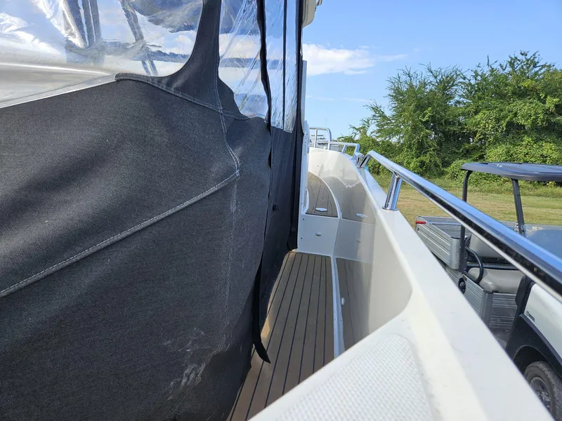 Slide: The Image of 2023 Nimbus Tender 8 boat with covered deck and sleek railing design. - 15