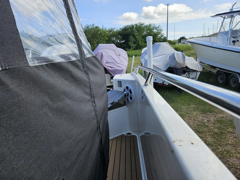 Slide: The Image of 2023 Nimbus Tender 8 boat with covered deck, parked outdoors on grass. - 17