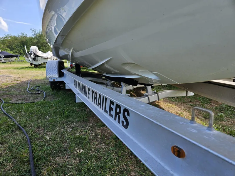 Slide: The Image of 2023 Nimbus Tender 8 on a marine trailer, parked on grassy area. - 19