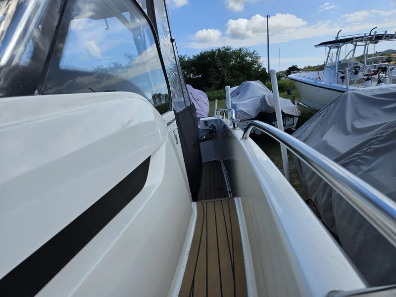 Slide: The Image of 2023 Nimbus Tender 8 boat with sleek design and wooden deck, docked outdoors. - 20