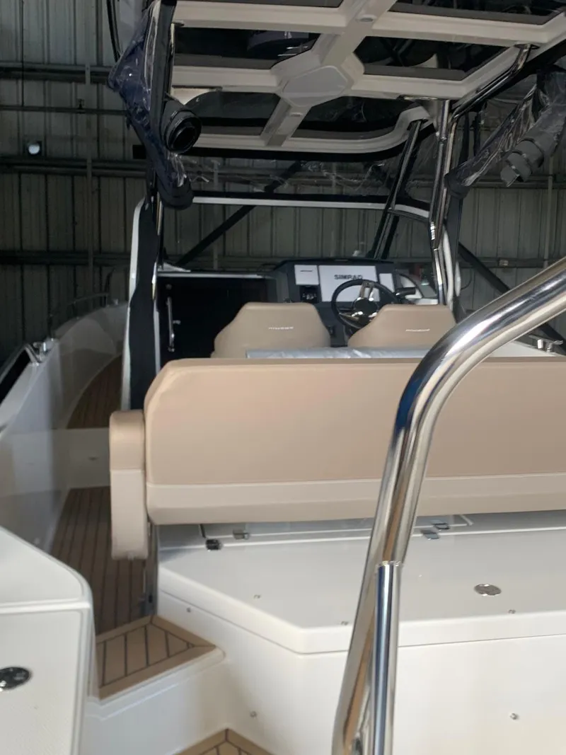 Slide: The Image of 2023 Nimbus Tender 8 boat interior with beige seating and modern dashboard. - 6