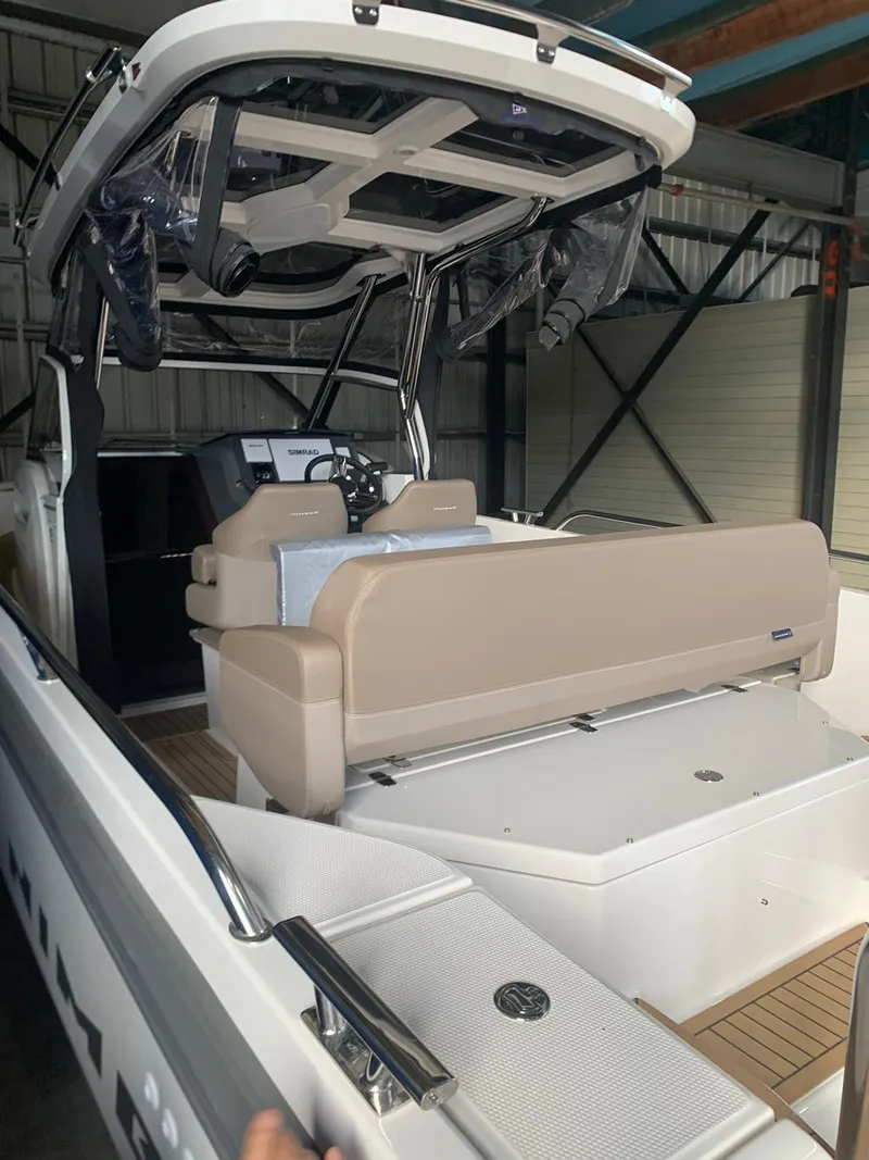 Slide: The Image of 2023 Nimbus Tender 8 boat interior with beige seating and modern dashboard. - 7