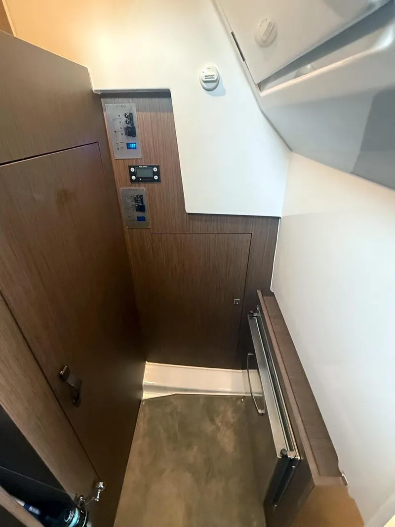 Slide: The Image of 2023 Beneteau Antares 11 OB interior with control panels and wood finish. - 13