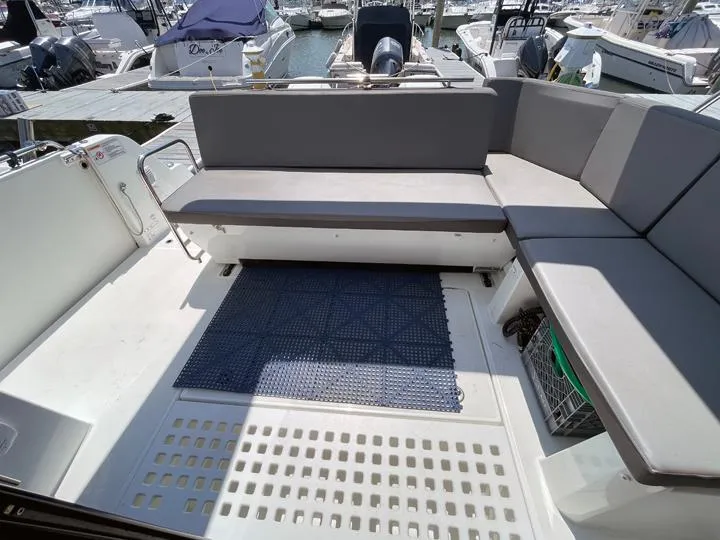 Slide: The Image of 2023 Beneteau Antares 11 OB boat deck with gray seating and blue mat. - 14