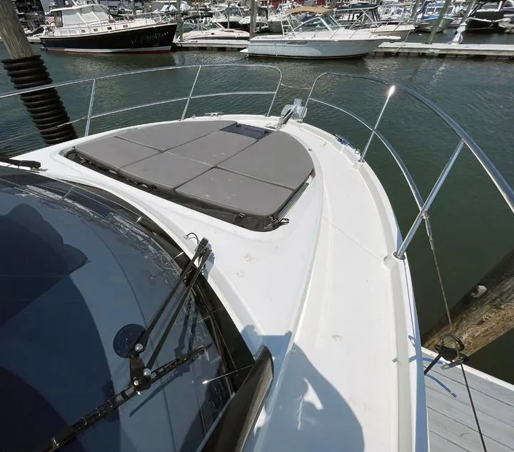 Slide: The Image of 2023 Beneteau Antares 11 OB boat deck with sunpad, docked in marina. - 2