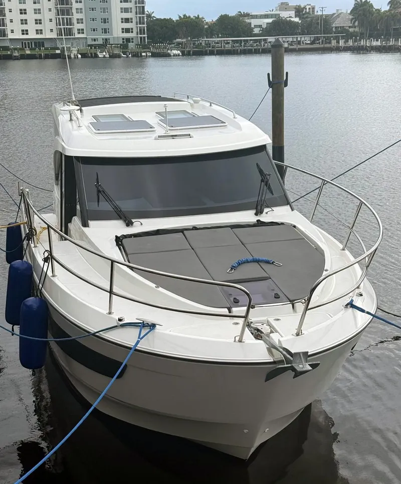 Slide: The Image of 2023 Beneteau Antares 11 OB boat docked in a marina, front view. - 3