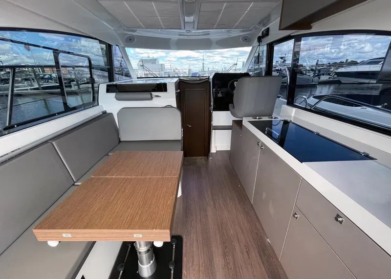 Slide: The Image of Interior of 2023 Beneteau Antares 11 OB, featuring seating, table, and helm station. - 5