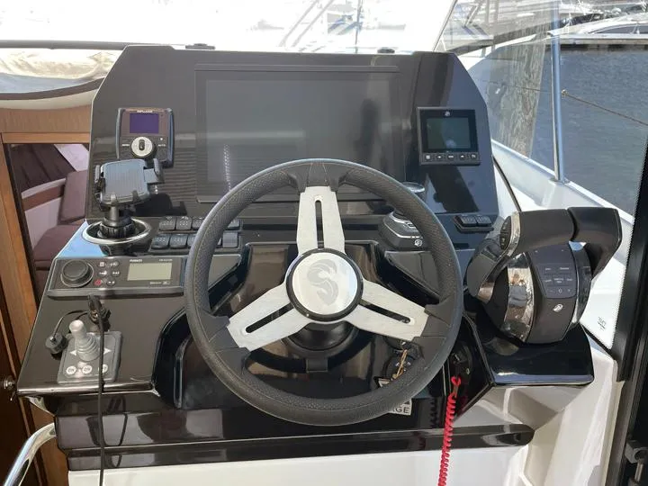 Slide: The Image of Helm of 2023 Beneteau Antares 11 OB with modern controls and navigation equipment. - 6