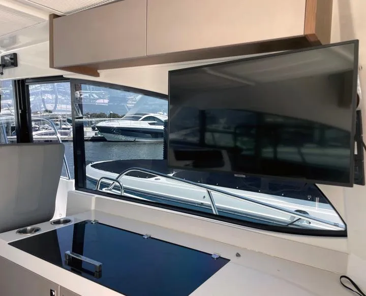 Slide: The Image of Interior of 2023 Beneteau Antares 11 OB with TV and marina view. - 8