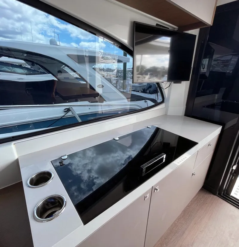 Slide: The Image of Modern kitchen area on 2023 Beneteau Antares 11 OB yacht with sleek countertop and window view. - 9