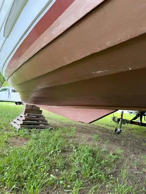 Slide: The Image of 1968 Lyman 19 boat hull on grass, supported by wooden blocks. - 14