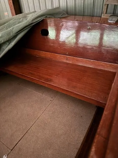 Slide: The Image of Wooden interior of a 1968 Lyman 19 boat, partially covered, showcasing polished woodwork. - 16