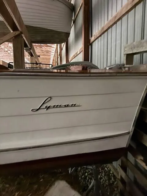 Slide: The Image of 1968 Lyman 19 boat in storage, showcasing classic wooden design. - 22