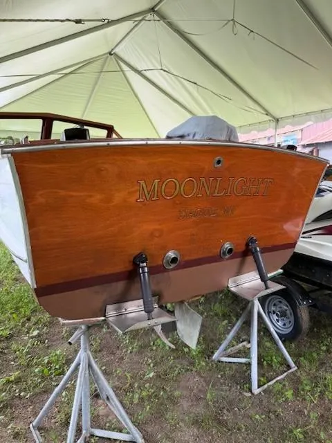Slide: The Image of 1968 Lyman 19 boat named "Moonlight" on stands under a tent. - 23