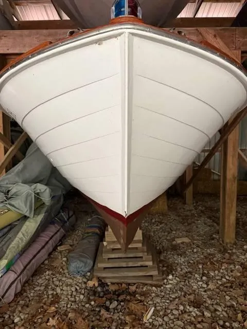 Slide: The Image of 1968 Lyman 19 boat stored indoors on wooden blocks, showcasing its white hull. - 4