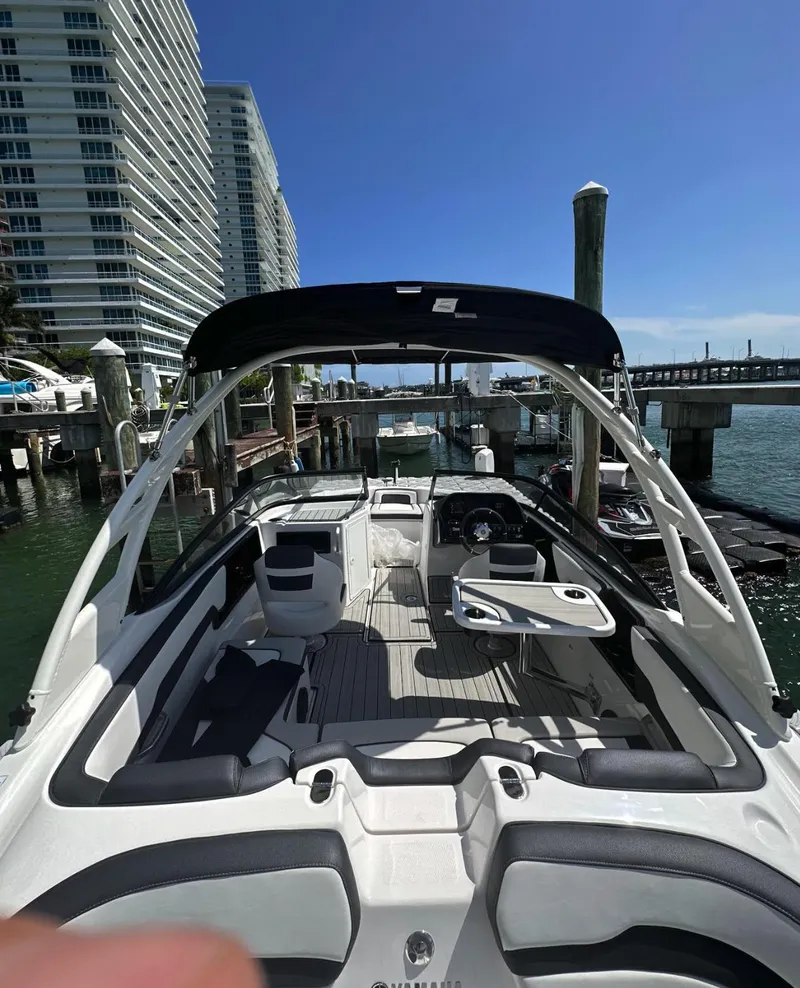 Slide: The Image of 2023 Yamaha AR195S boat docked at marina with modern buildings in background. - 4