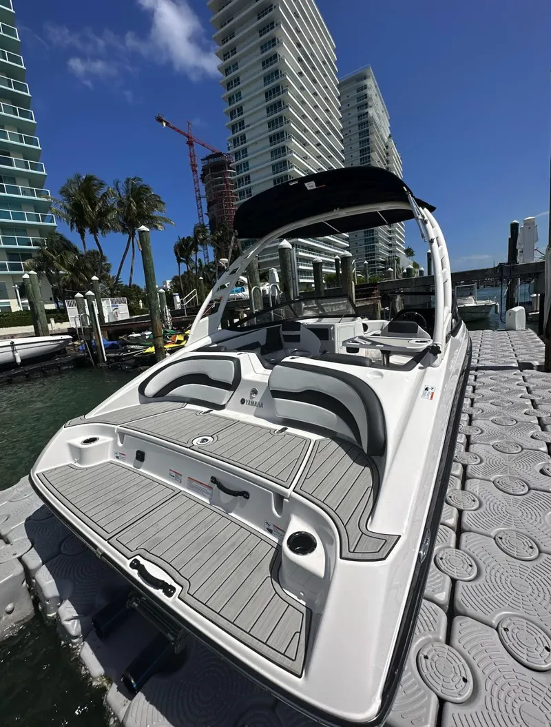 Slide: The Image of 2023 Yamaha Boats AR195S docked near modern high-rise buildings. - 5