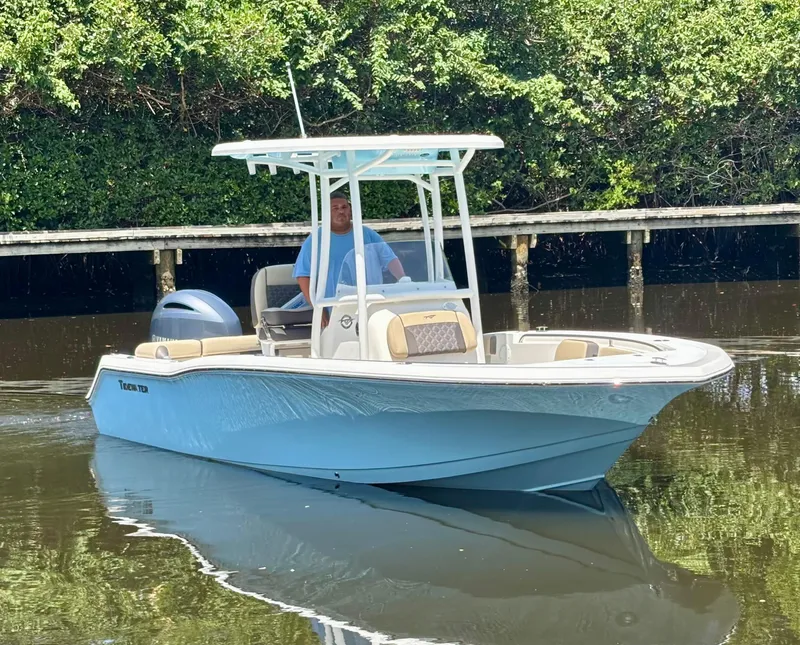 Slide: The Image of 2022 Tidewater 210 LXF boat on calm water, featuring sleek design and modern features. - 0
