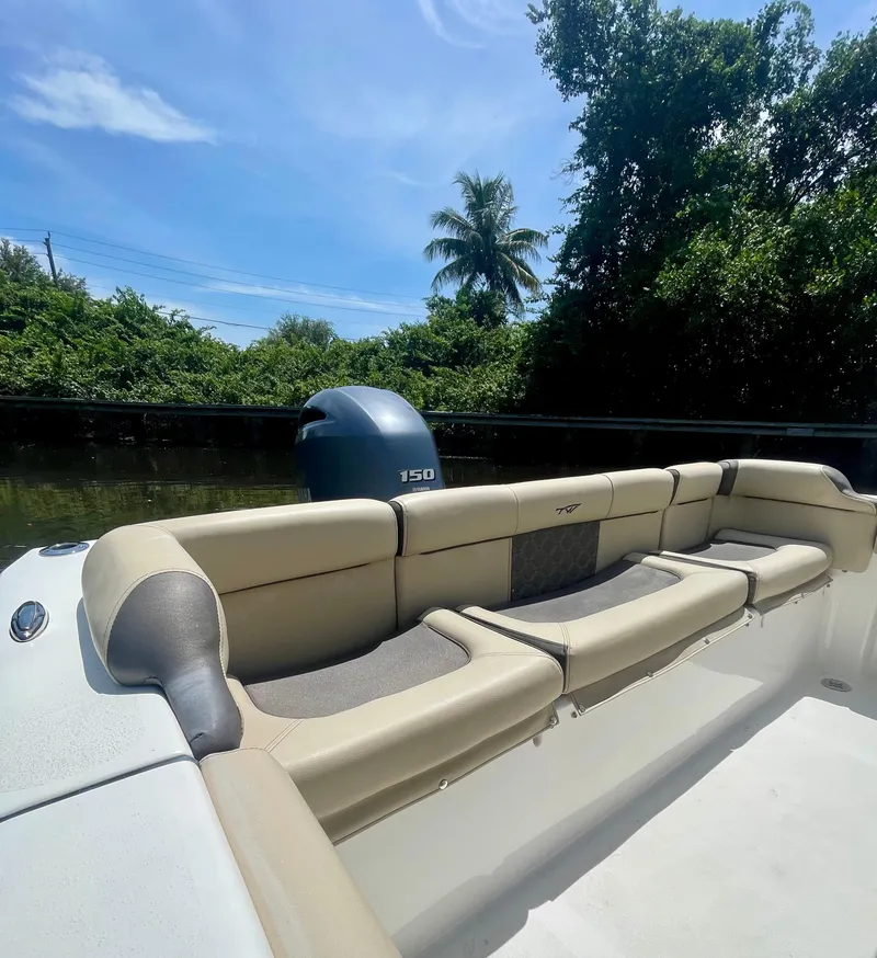 Slide: The Image of 2022 Tidewater 210 LXF boat interior with seating and outboard motor, surrounded by lush greenery. - 3