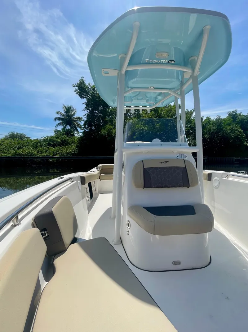 Slide: The Image of 2022 Tidewater 210 LXF boat with seating, under a clear blue sky. - 4