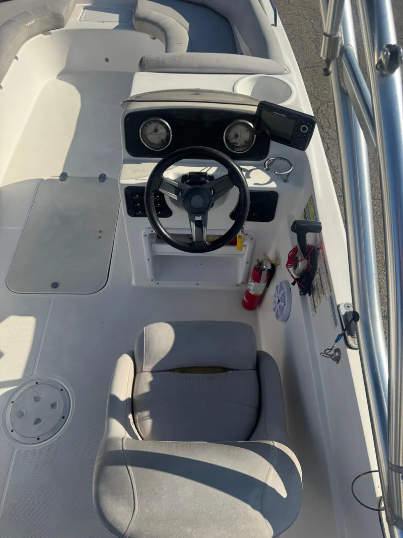 Slide: The Image of 2017 Hurricane SunDeck Sport 201 OB boat cockpit with steering wheel and seating. - 9