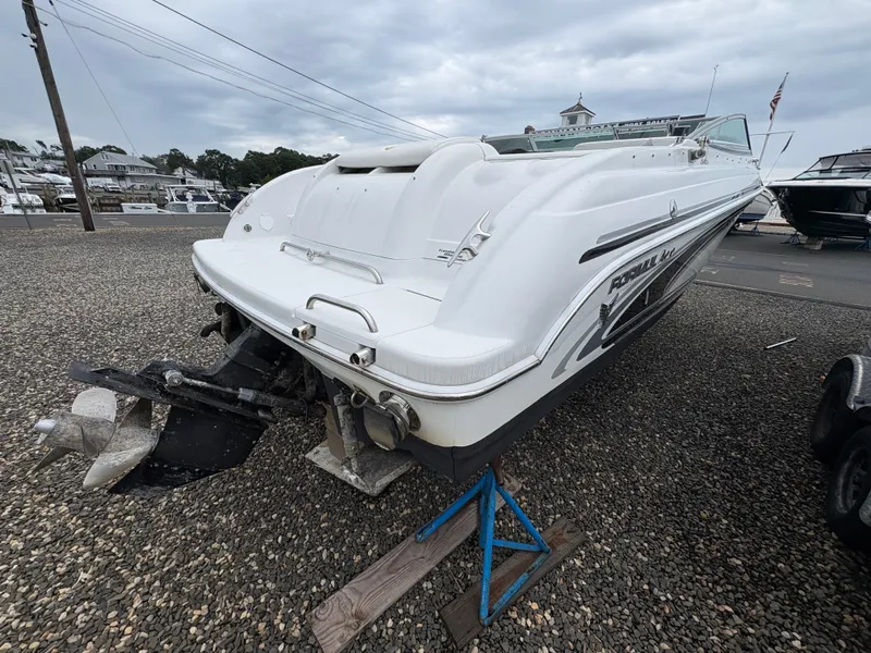 Slide: The Image of 2004 Formula 260 Bowrider boat on gravel lot, rear view with outboard motor. - 3