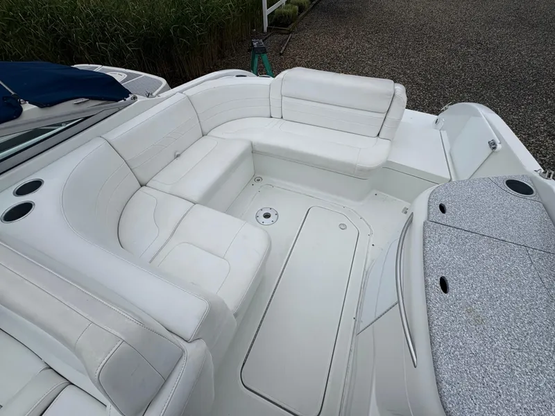 Slide: The Image of 2004 Formula 260 Bowrider with white seating and cup holders, docked on gravel. - 8