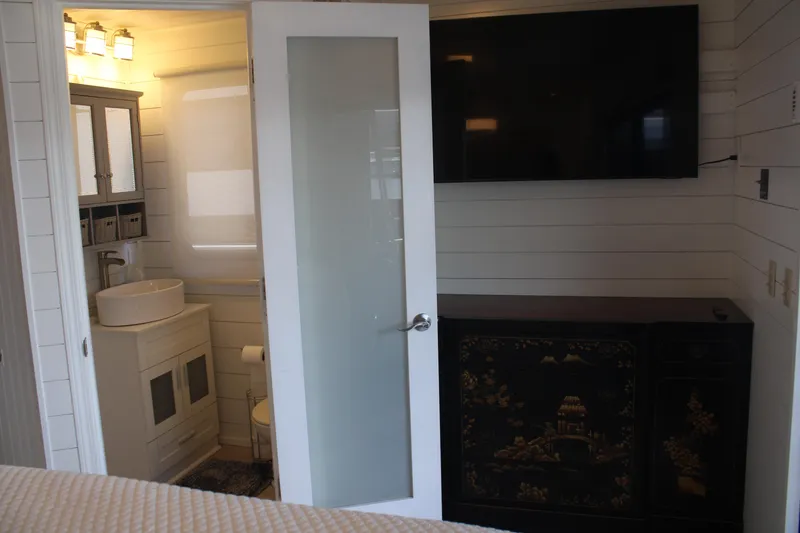 Slide: The Image of Cozy bedroom interior in 1992 Sumerset 66 houseboat with white bedding and blue pillows. - 30