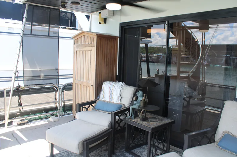 Slide: The Image of Outdoor seating area on a 1992 Sumerset 66 houseboat with cushioned chairs and a ceiling fan. - 36