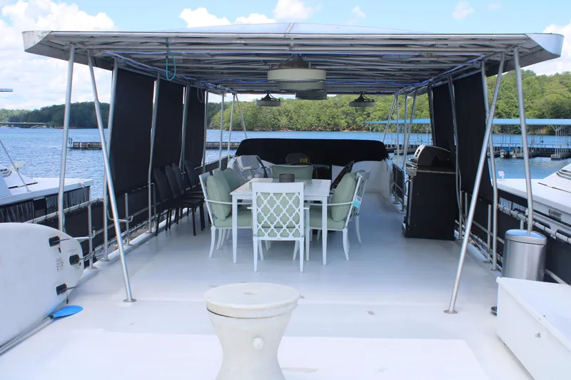 Slide: The Image of 1992 Sumerset 66 houseboat docked, featuring a slide and spacious deck under a blue sky. - 42