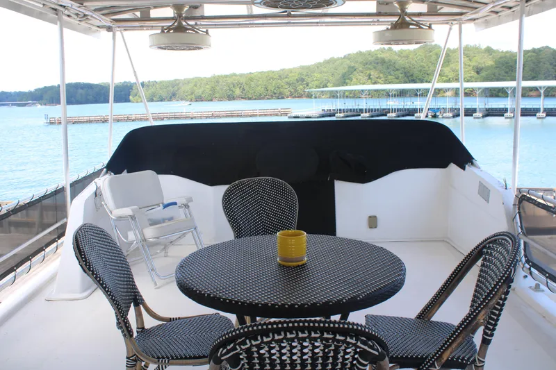 Slide: The Image of Outdoor dining area on 1992 Sumerset 66 houseboat, featuring cushioned chairs and a waterfront view. - 46